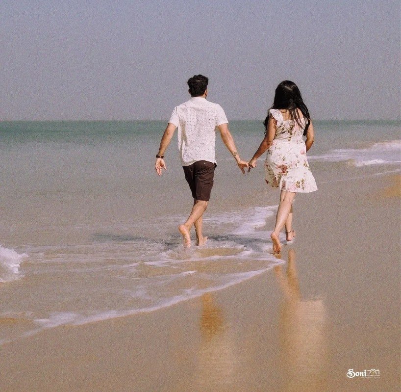 Couple walking hand in hand along the shore