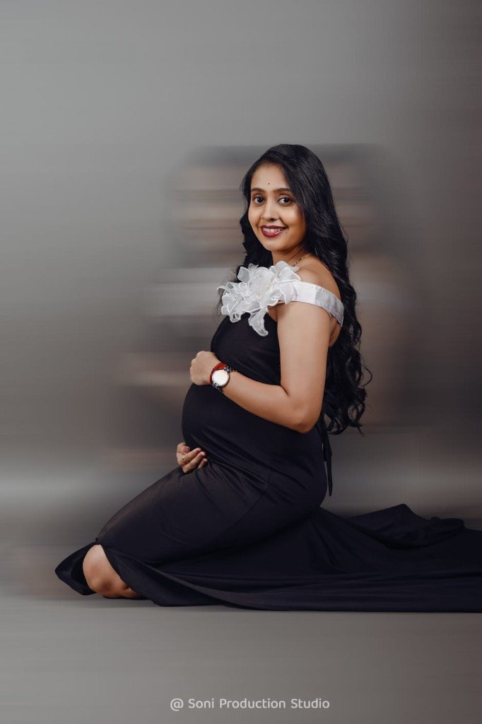 Maternity portrait in a black gown with soft motion blur