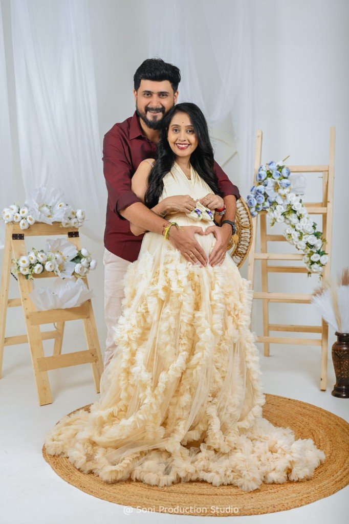 Couple maternity portrait with baby booties