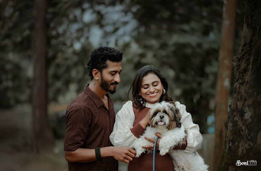Maternity couple with their dog in the woods