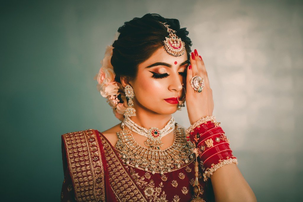 Bridal makeup close-up with gold jewellery and red lipstick
