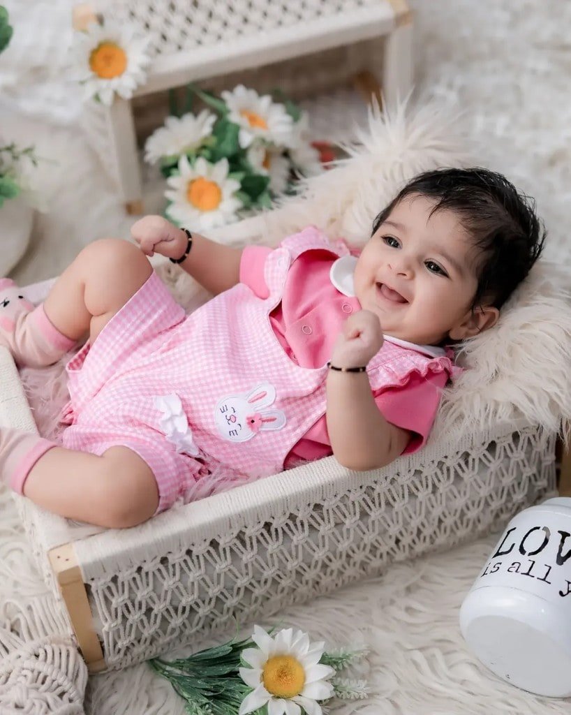Baby portrait in a daisy-lined studio cradle