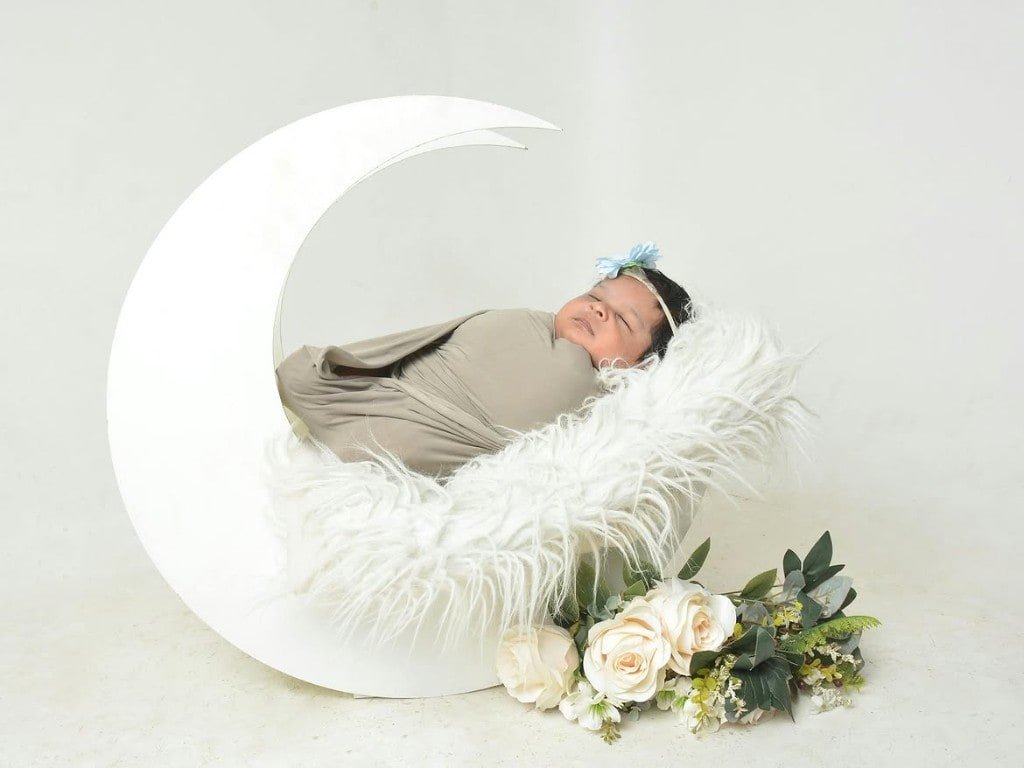 Sleeping newborn in a crescent moon prop