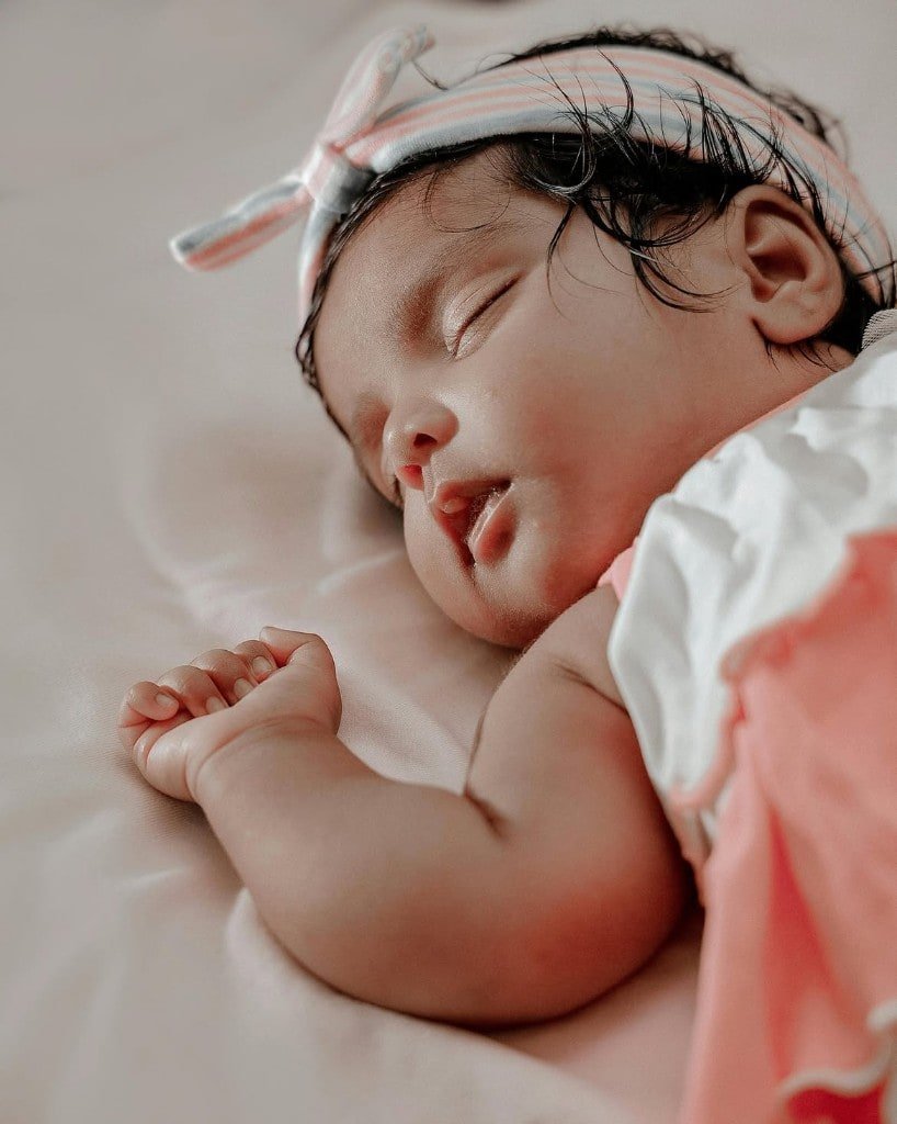 Sleeping newborn close-up in pink