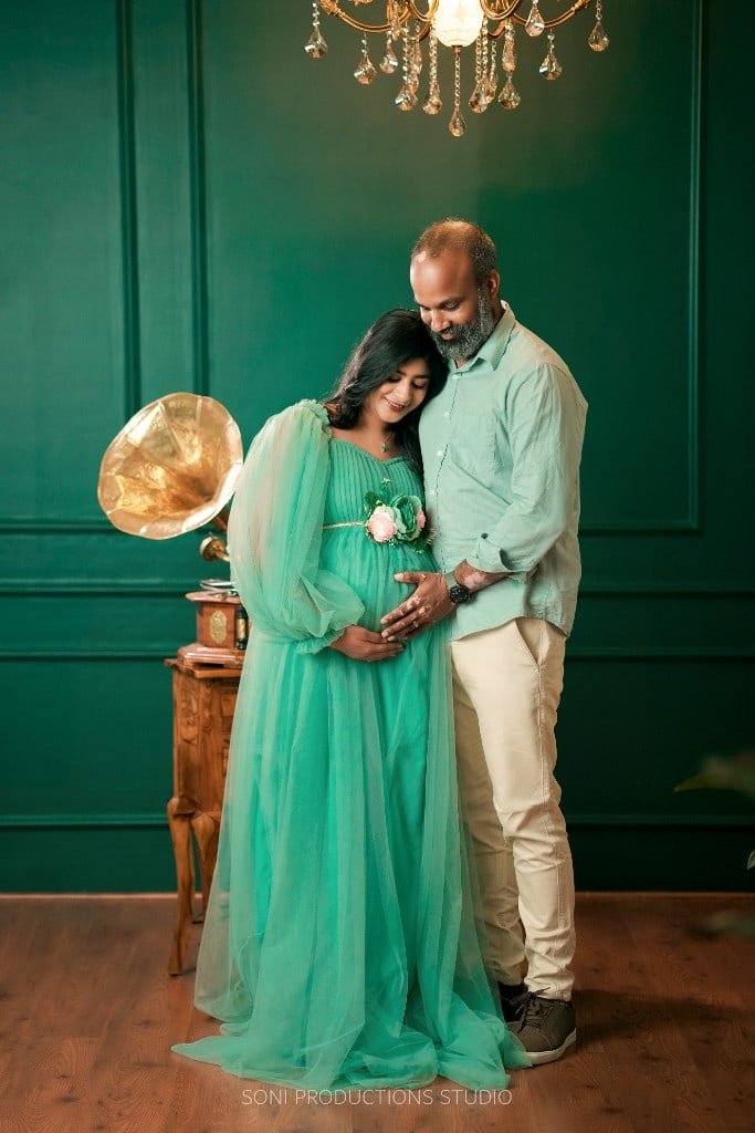 Couple maternity portrait with baby booties