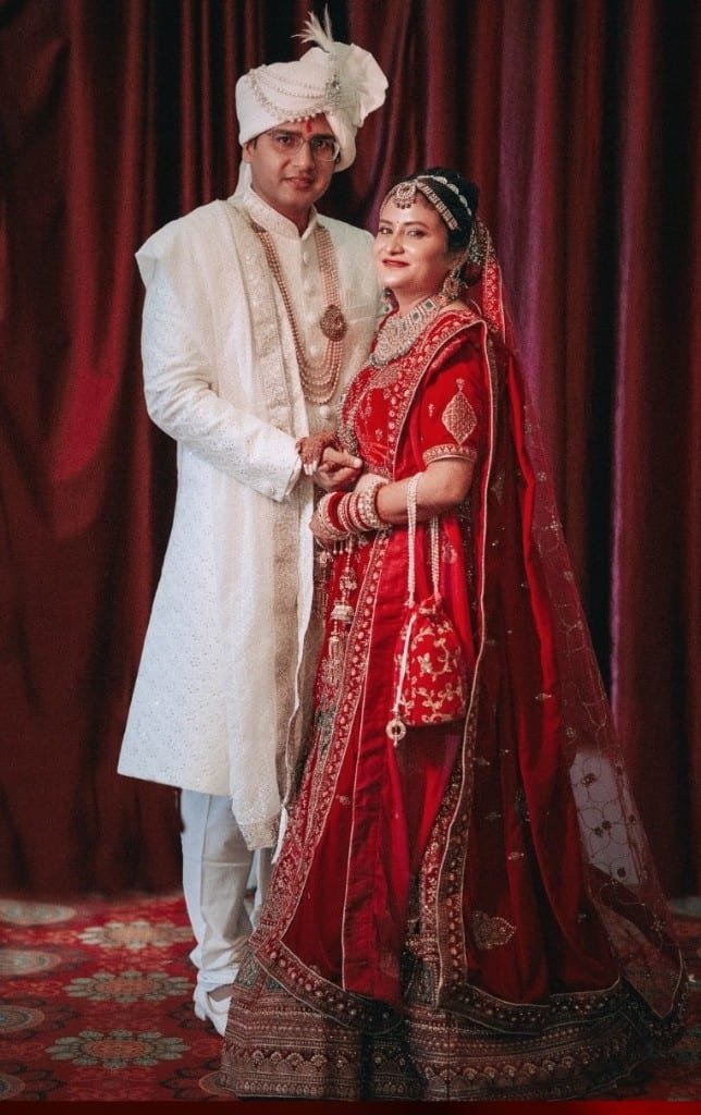 Wedding couple in red lehenga and white sherwani