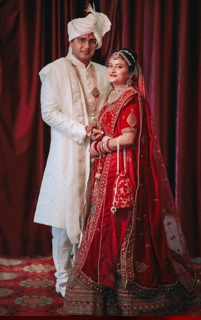 Wedding couple in sherwani and red lehenga